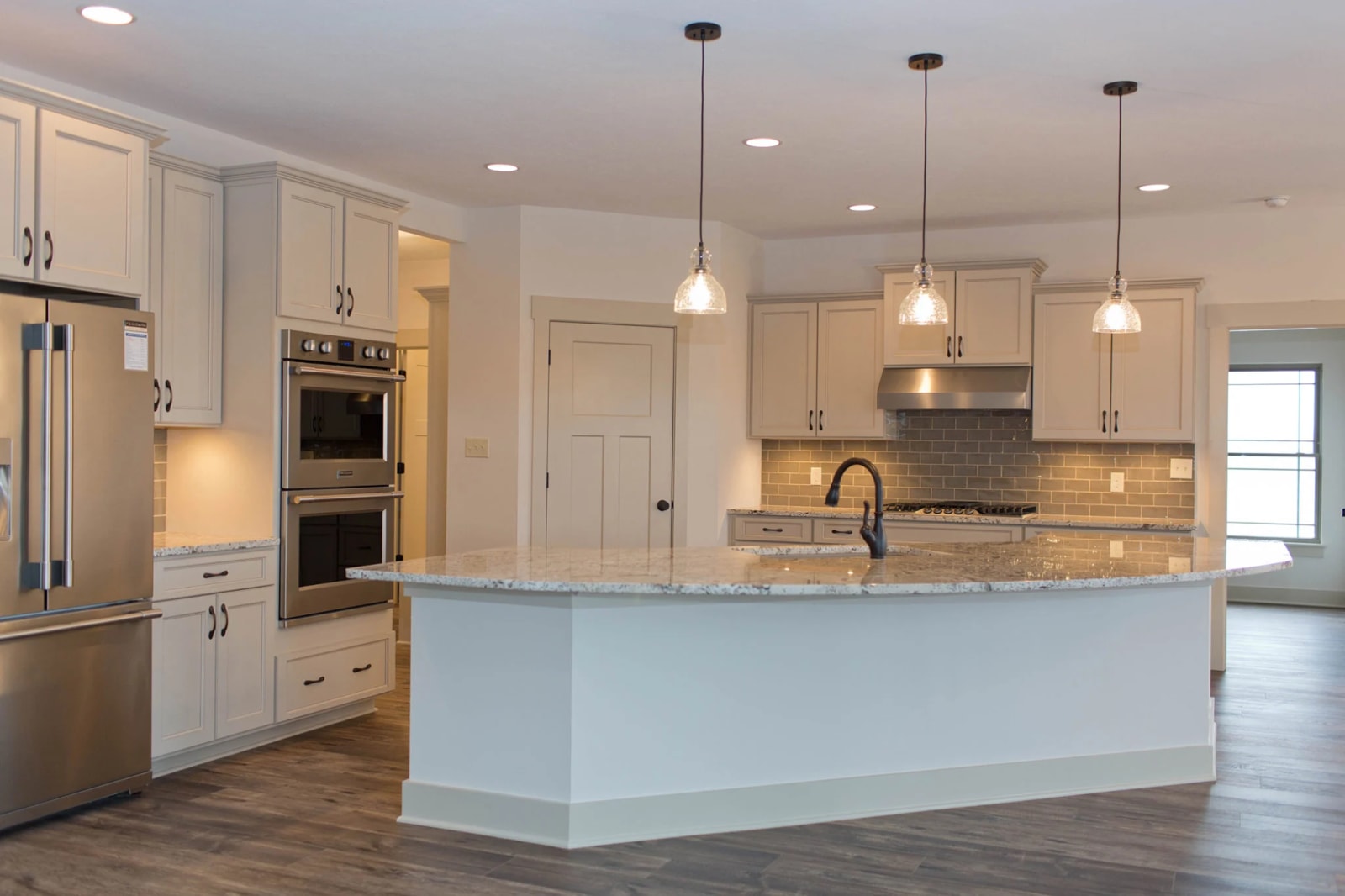 Painted kitchen cabinetry with a large central island and pendant lighting